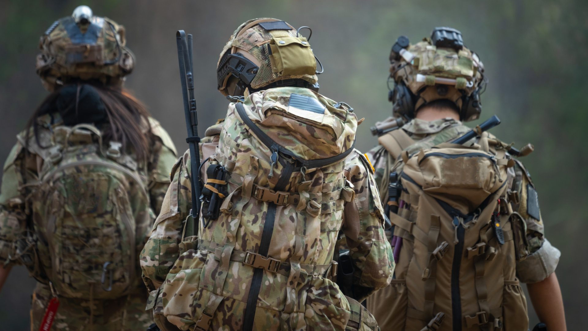 Backside of Three Soldiers Wearing Full Gear and Walking Together Outside