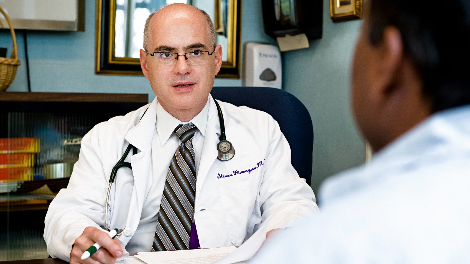 Dr. Steven R. Flanagan Speaking with Colleague in Office