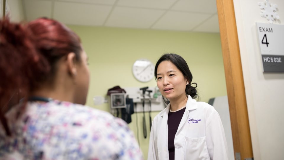 Dr. Melissa Sum Speaking with Colleague in Exam Room