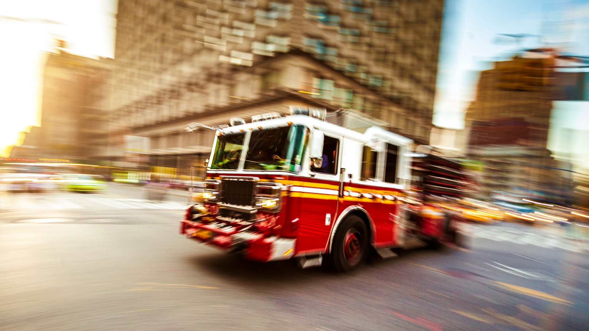 Fire truck driving through blurred city street