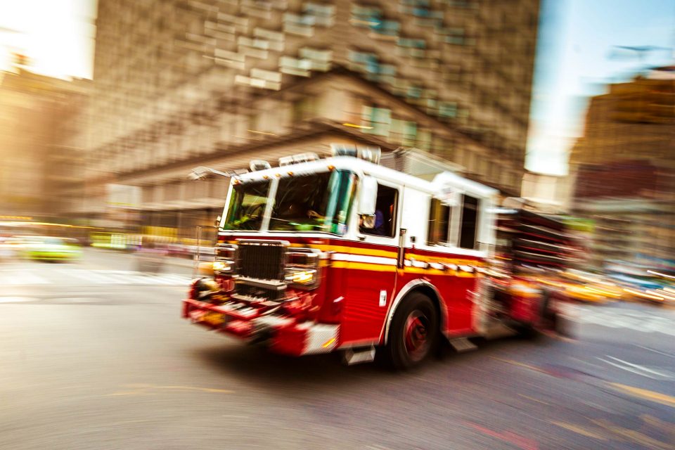 Fire truck driving through blurred city street