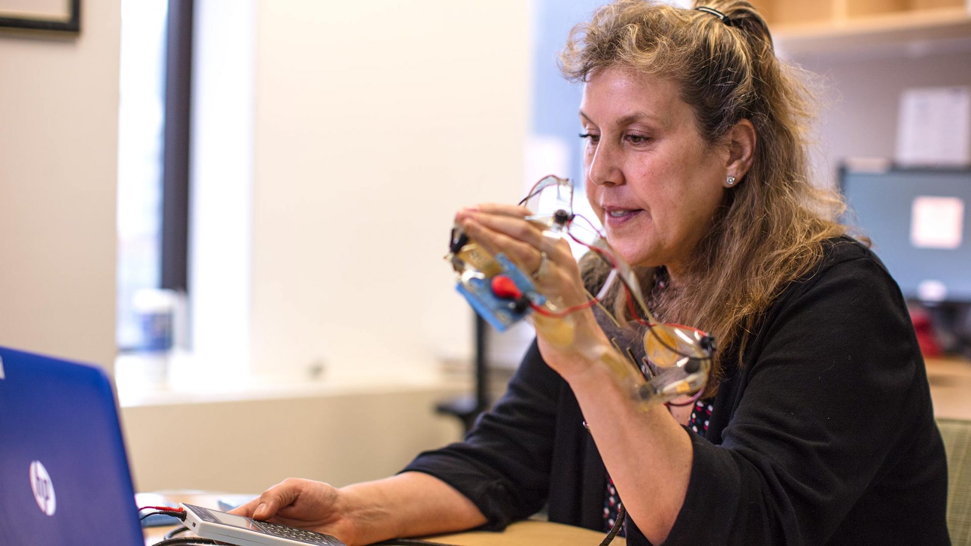 Dr. Leigh E. Charvet conducting telehealth tDCS appointment with patient through a laptop