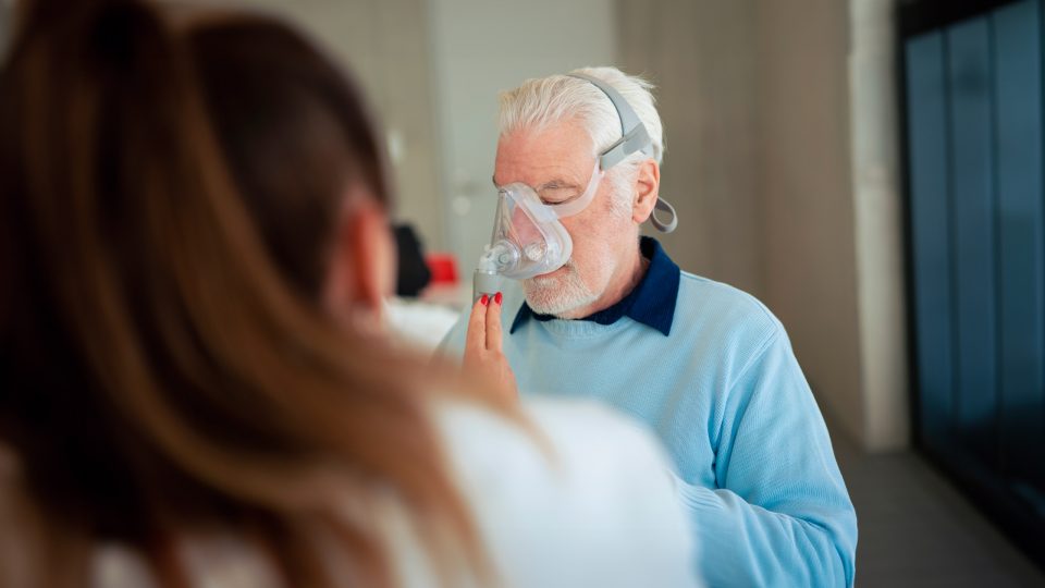 Doctor helping patient using nebulizer